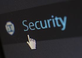 Close-up view of a mouse cursor over digital security text on display.